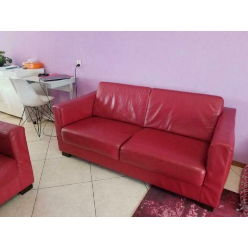 Rode banken met stoelen en grijs tweepersoons slaapbed