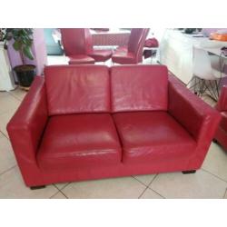 Rode banken met stoelen en grijs tweepersoons slaapbed