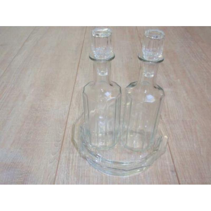 Olie en azijn flesje van glas op schaaltje