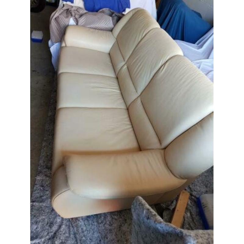 Leren bank.Drie zits plus twee stoelen. Creme kleur